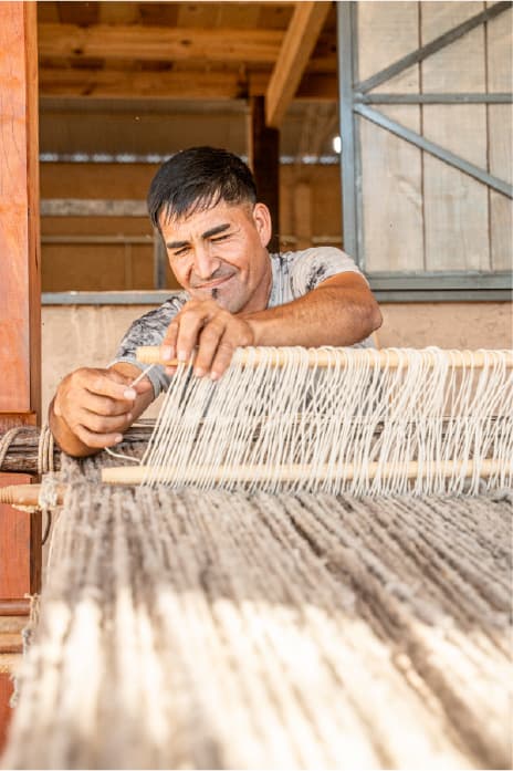 Artesano tejiendo en telar